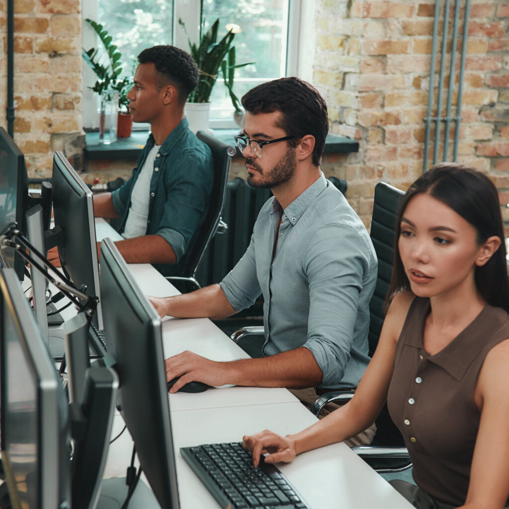 Team of IT developers working together in a team environment.